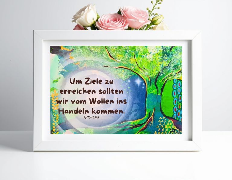 Weißer Bilderrahmen mit einem farbenfrohen Gemälde, das einen Baum mit grünen Blättern und dem Zitat "Um Ziele zu erreichen sollten wir vom Wollen ins Handeln kommen." von Anton Saur zeigt, platziert vor einem weißen Hintergrund mit einem Strauß rosa und weißer Rosen oben.